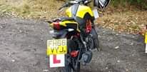 Image may contain: ‎one or more people, motorcycle and outdoor, ‎text that says "‎ט VYJ. FH66‎"‎‎